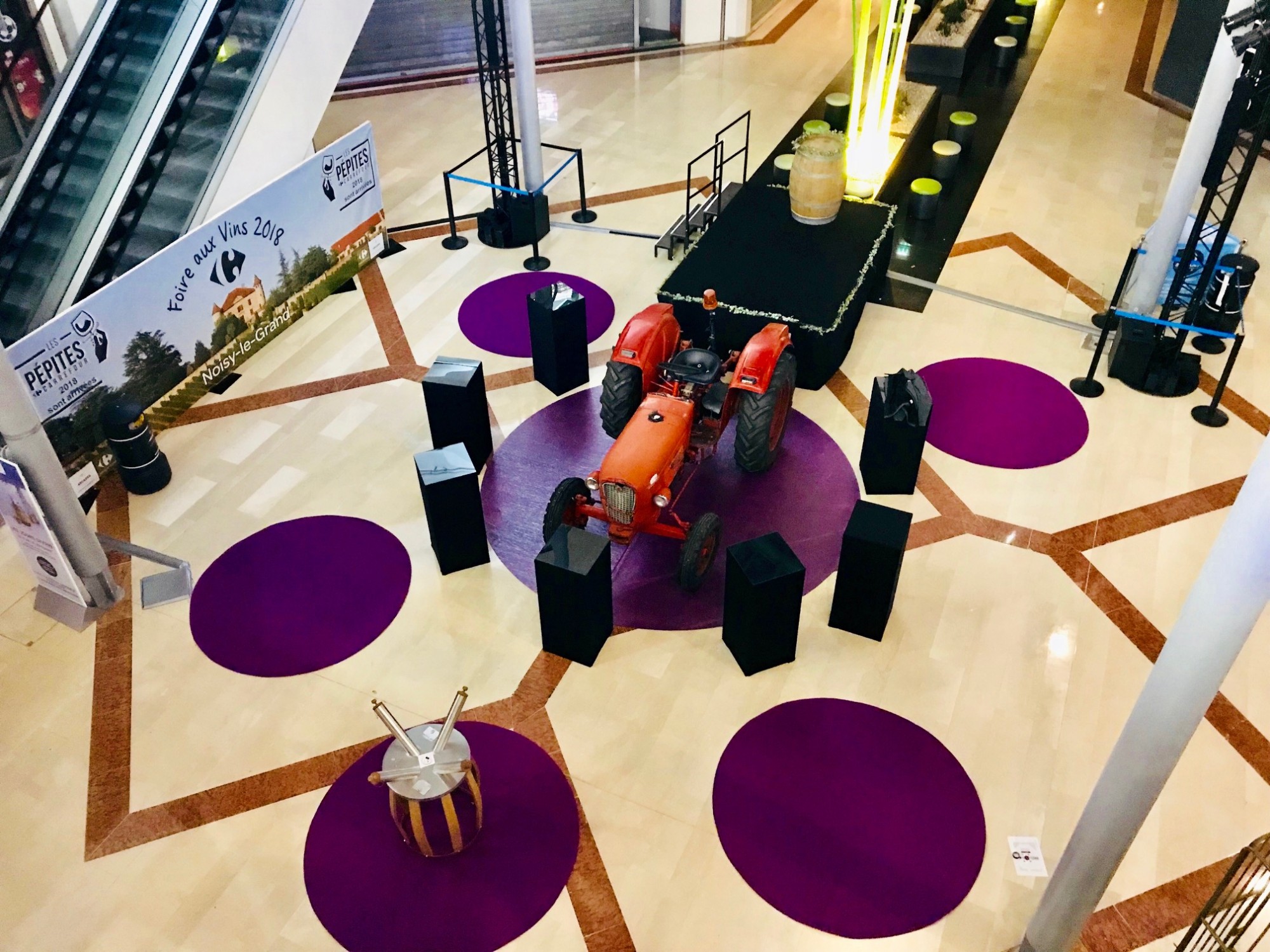 Mise en place de Moquette violette, Tonneaux à vin et présentoirs d'exposition lors de la foire aux Vins 2018 au Centre Commercial Les Arcades